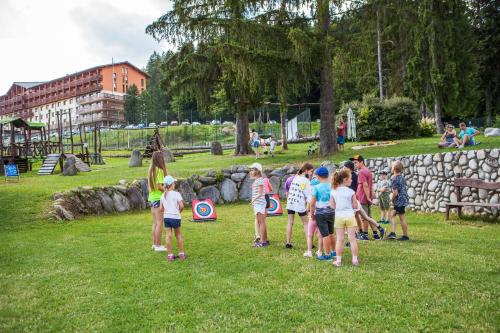 a group of children standing around in a park at Hotel Partizán in Tale