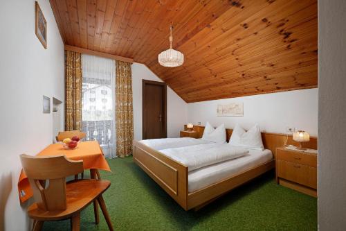 a bedroom with a bed and a wooden ceiling at Gasthof Mesnerwirt in Auna di Sopra