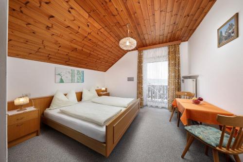 a bedroom with a bed and a desk and a table at Gasthof Mesnerwirt in Auna di Sopra