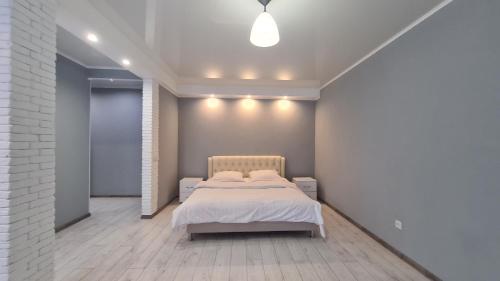 a bedroom with a bed and a white wall at Apartaments on vulytsia Heroiv Ato 32 (97th Kvartal) in Kryvyi Rih