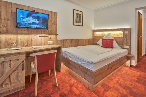 a bedroom with a bed and a desk and a television at Hotel St. Georg Garni in Celle