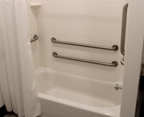 a bath tub in a bathroom with two towel bars at Best Western Plus Isanti in Isanti