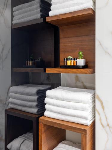 a pile of towels on a shelf in a bathroom at Amazon Hotel in Athens
