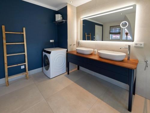 a bathroom with two sinks and a washing machine at Mönchguter Reethus mit Wasserblick, Kamin, Sauna in Alt Reddevitz