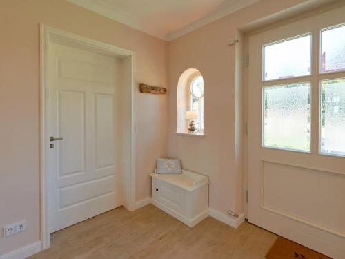 a bathroom with a toilet and a window and a door at Mönchguter Reethus mit Wasserblick, Kamin, Sauna in Alt Reddevitz
