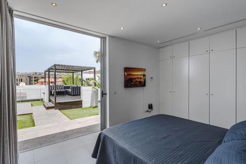 a bedroom with a bed and a large window at Lux Villa 31 in Adeje