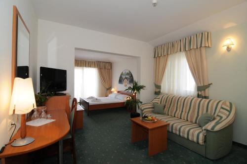 Habitación de hotel con sofá y mesa en Hotel Rosina, en Makarska