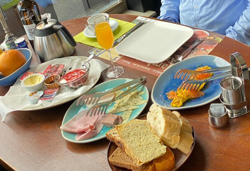 een houten tafel met borden met eten erop bij De Post B&B Restaurant in Klimmen