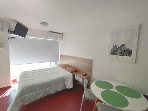 a bedroom with a bed and a table in it at Depto Mancora in Rosario