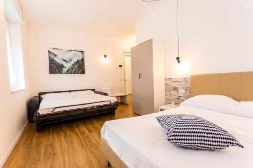 a hotel room with two beds and a desk at CASA SAN PAOLO Rooms And Apartments in Trento