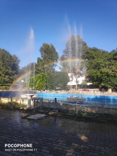 a fountain with a rainbow in a park at Iris&carina in Eforie Sud