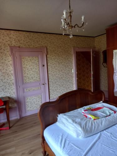 a bedroom with a bed with a wooden frame and a door at 2 chambres d'hôtes privées louées séparément avec communs à partager in Beaufort