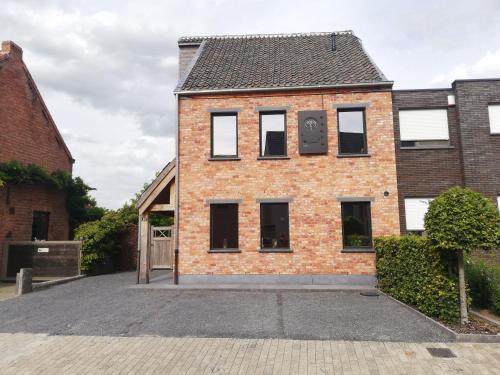 an old brick building with a clock on it at B&B Fagus in Buggenhout