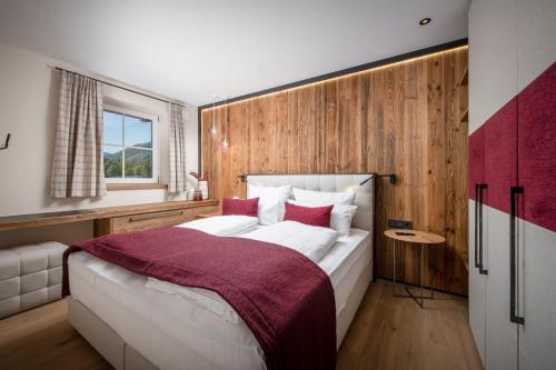 a bedroom with a large bed with a wooden wall at Luxury Apartments "R6 Tegernsee" in Bad Wiessee