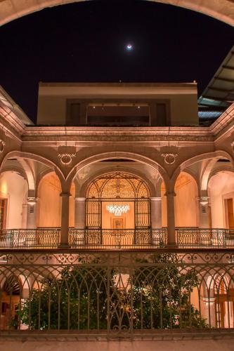 a building with a balcony with a chandelier at Casa Grande Hotel Boutique in Morelia