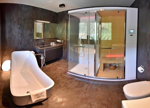 a bathroom with a shower and a sink and a tub at Divota Townhouse in Split
