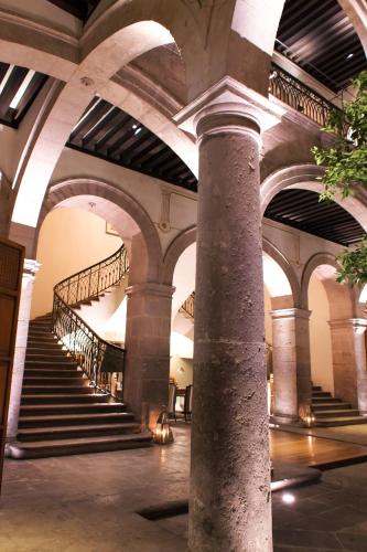 a spiral staircase in a building with a column at Casa Grande Hotel Boutique in Morelia
