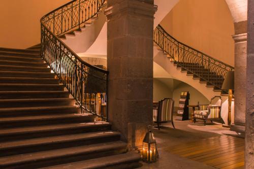 a spiral staircase in a house with a pillar at Casa Grande Hotel Boutique in Morelia