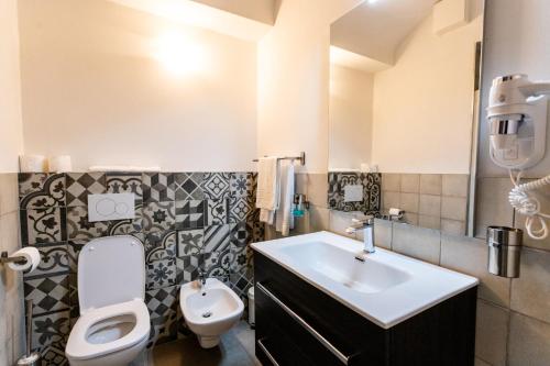 a bathroom with a white toilet and a sink at ALPENCITY SUITES in Trento