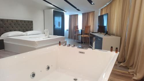a bedroom with two beds and a bath tub at Star Hotel in Tirana