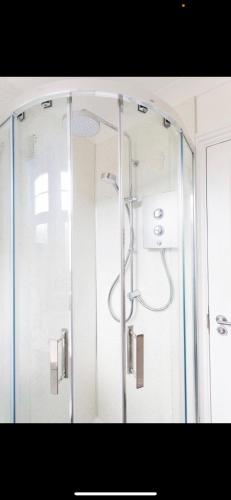 y baño con ducha y puerta de cristal. en Driftwood Luxury Apartment, en Lyme Regis