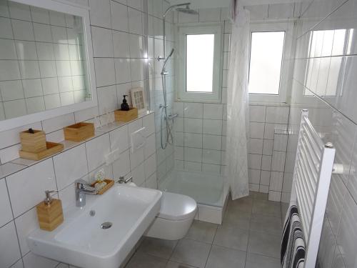 a white bathroom with a sink and a toilet at FeWo am Deister in Bad Münder am Deister