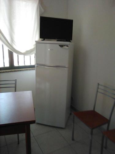 einen weißen Kühlschrank mit einem TV darüber in der Unterkunft Casa vacanze in Bianco