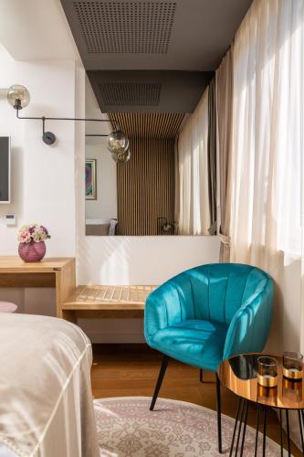 a bedroom with a blue chair and a bed at V Luxury Apartment in Split