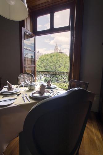 a dining table with a view of a window at Casa Grande Hotel Boutique in Morelia