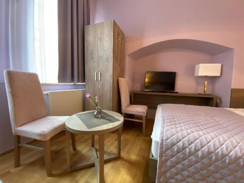 a hotel room with a bed and a table and chairs at Pension Jeske Heidelberg in Heidelberg