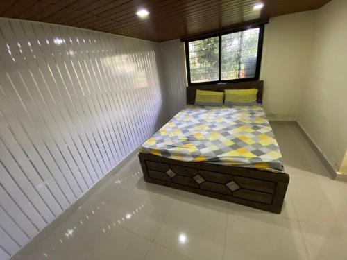 a small bedroom with a bed in a room at Farmhouse in Pune city in Pune
