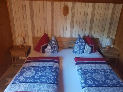 1 dormitorio con 2 camas y almohadas azules y rojas en Ferienwohnung Dressler, en Pfronten