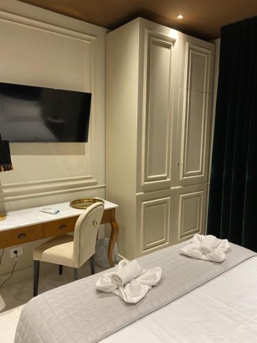 1 dormitorio con escritorio y 1 cama con toallas blancas en Apartment Rooms Luxury SIANO Joseph, en Rímini