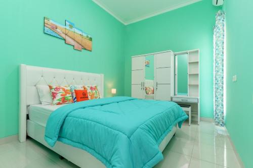 una camera blu con letto e specchio di KoolKost @ Ikost Cimahpar Indah a Bogor