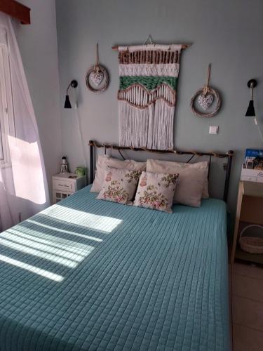 een slaapkamer met een bed met een groen dekbed bij Anastasia's holiday house with garden in Ialyssos