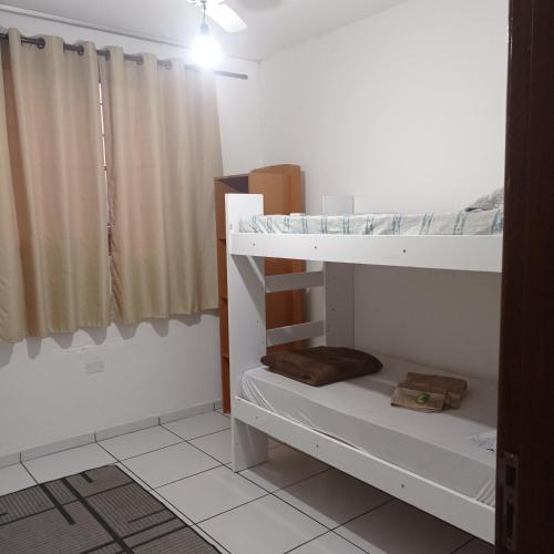 カンポス・ドス・ゴイタカゼスにあるApto Carioca Shoppingの二段ベッド2台とカーテンが備わる客室です。