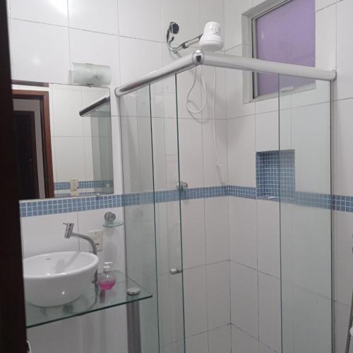 a bathroom with a glass shower with a sink at Apto Carioca Shopping in Campos dos Goytacazes