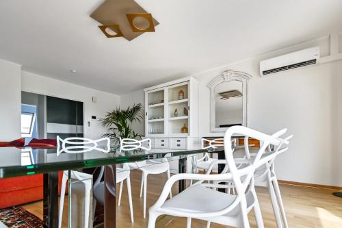 une cuisine avec une table en verre et des chaises blanches dans l'établissement Le Saint-Eloi Luxury Apt private parking with AC 6 pers Colmar old town, à Colmar