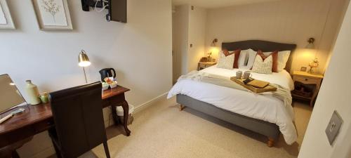 a bedroom with a bed and a desk with a computer at The Family Tree in Whatstandwell