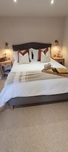 a bedroom with a large bed with white sheets and pillows at The Family Tree in Whatstandwell