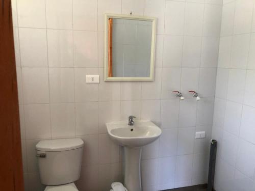 ein Badezimmer mit einem Waschbecken, einem WC und einem Spiegel in der Unterkunft Cabañas en Algarrobo Norte in Algarrobo