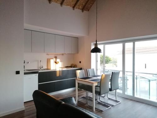 a kitchen and dining room with a table and chairs at A Casinha in Caldas da Rainha