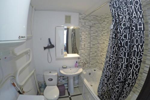 a bathroom with a sink and a toilet and a shower curtain at Уютная квартира со свежим ремонтом in Odesa