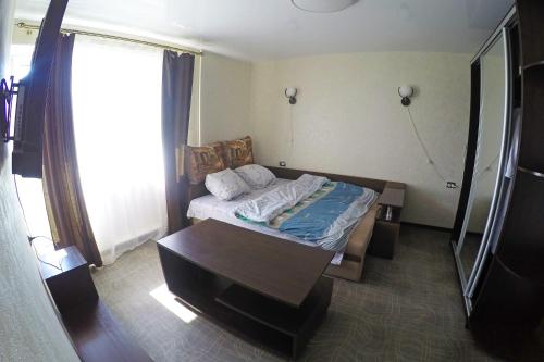 a bedroom with a bed with a table and a window at Уютная квартира со свежим ремонтом in Odesa