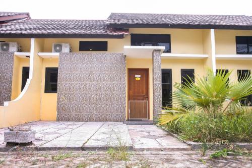 una casa con una puerta delante de ella en OYO 3438 Pasir Padi Inn Syariah, en Kebinti