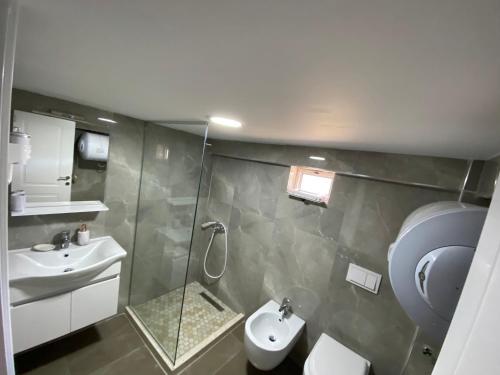 een badkamer met een douche, een toilet en een wastafel bij Green Villa in Korçë