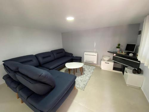 a living room with a blue couch and a table at Green Villa in Korçë