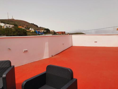 balcón con 2 sillas y suelo de color naranja en V.V JUANA, en Valverde