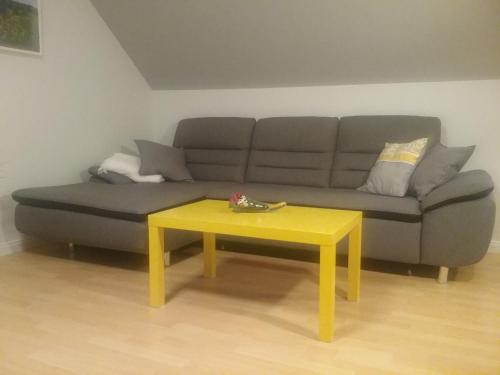 a living room with a couch and a yellow table at Haus Holldack Wohnung Maria in Goldenstedt