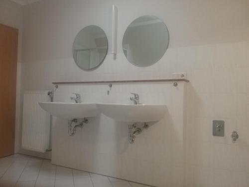 a bathroom with a sink and two mirrors on the wall at Haus Holldack Wohnung Maria in Goldenstedt